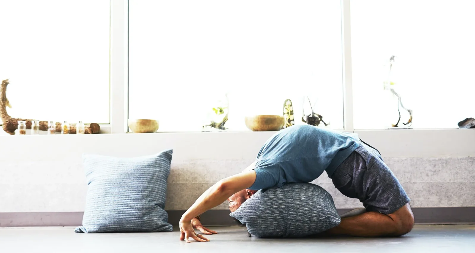 Person som utför en yogaposition på en matta