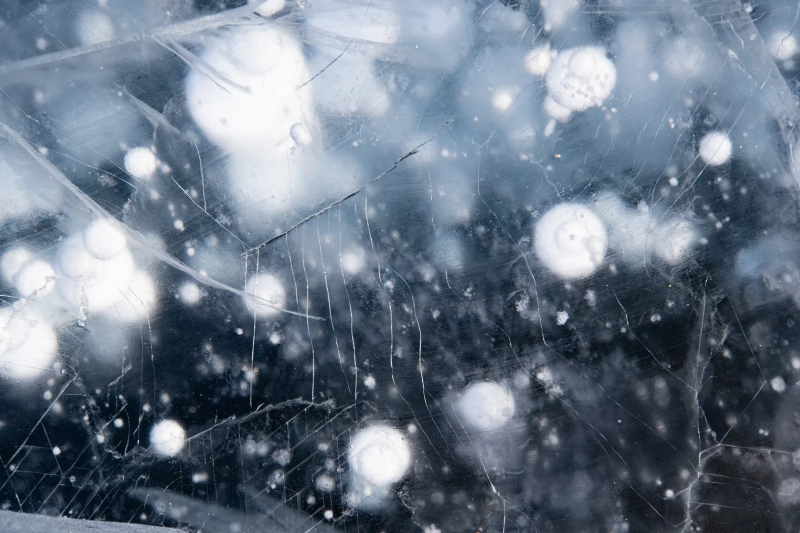 Abstrakt makrofoto av frost och trådar på en isig glasyta
